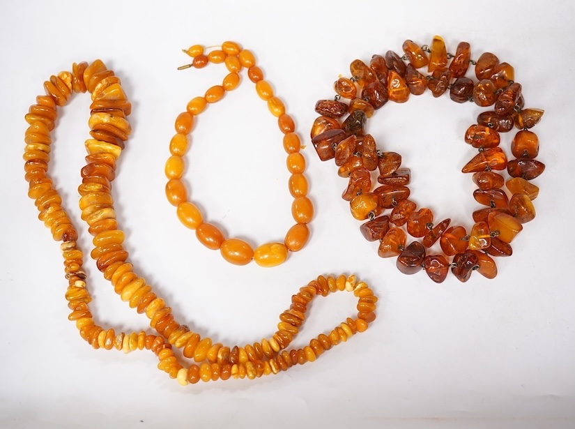 Three assorted amber necklaces including a single strand graduated oval bead necklace, 40cm, gross weight 37 grams, the other two necklaces gross weight 240 grams. Condition - poor to fair